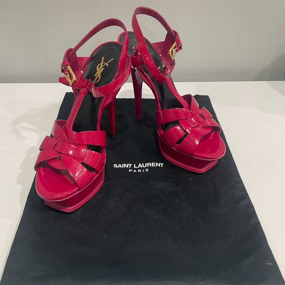 pair of Saint Laurent Tribute Platform Sandals in pink patent leather.